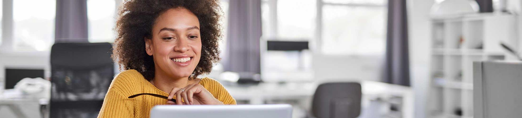 Woman smiling at her desk in her office.